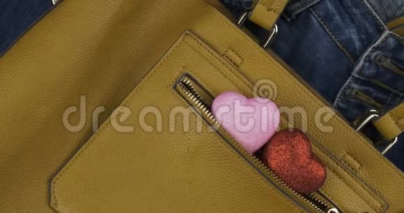两颗心从一个女黄包的口袋里伸出轮换爱和时尚的背景视频的预览图