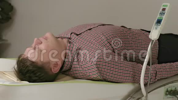 一个男人躺在按摩床上用玉辊按摩视频的预览图