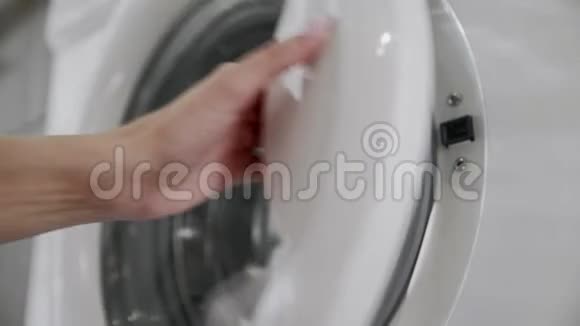 带结婚戒指的女性手从洗衣机里取出白色的衣服去装洗衣机把衣服装上洗衣机视频的预览图