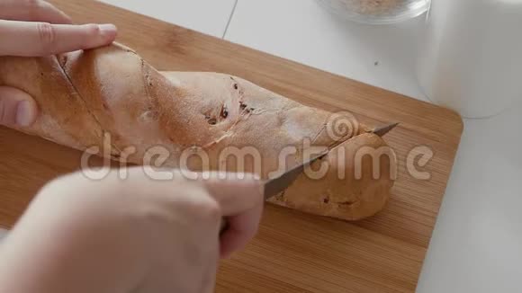 近距离观看用面包刀切面包的女人视频的预览图