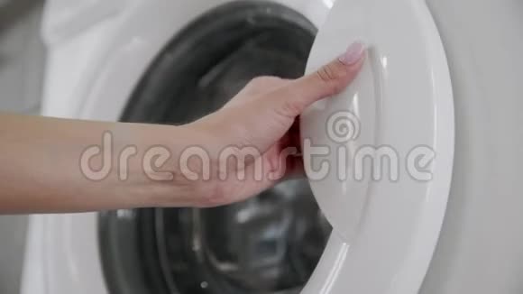 女性的手与已婚戒指放置白色的颜色从洗衣机去装洗衣机把衣服装上洗衣机视频的预览图