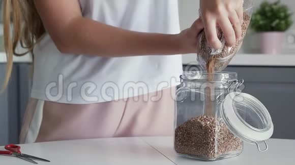 将荞麦倒入一个玻璃罐中存放视频的预览图