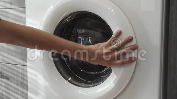 带结婚戒指的男性手从洗衣机里取出黑色的衣服去装洗衣机把衣服装上洗衣机视频的预览图