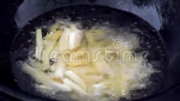 炸薯条放在平底锅里里面有煮沸的油切片土豆沸腾在油特写视频的预览图