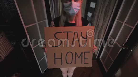 戴着面具的女人手里拿着一条信息给人们留在家里检疫视频的预览图