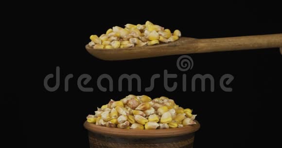 玉米粒从一个木勺上得到足够的睡眠在一堆种子在一个粘土碗视频的预览图