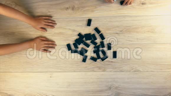 在家庭多米诺骨牌游戏中搅动桌子上的多米诺骨牌从上面看视频的预览图