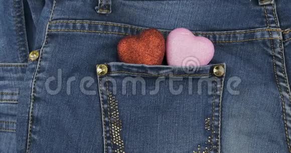 放大两颗象征的心从牛仔裤的后口袋里伸出特写情人节视频的预览图
