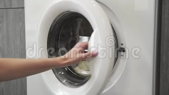 带结婚戒指的女性手从洗衣机里拿了两个白色的手表去装洗衣机把衣服装上视频的预览图