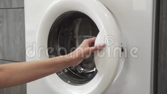 有结婚戒指的女性手把两个白色的SWEATER放在洗衣机里去装洗衣机把衣服装上视频的预览图