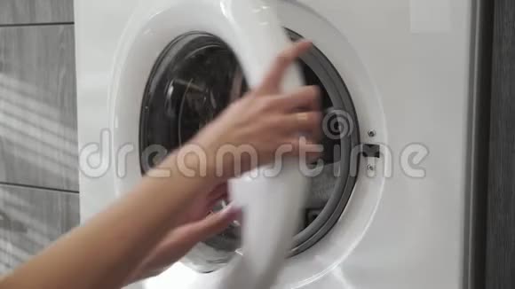 带结婚戒指的女性手从洗衣机里拿着绿色的衣服去装洗衣机把衣服装上洗衣机视频的预览图