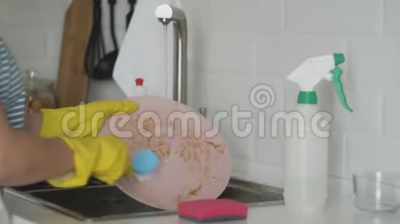 女人在厨房的水槽里洗碗视频的预览图