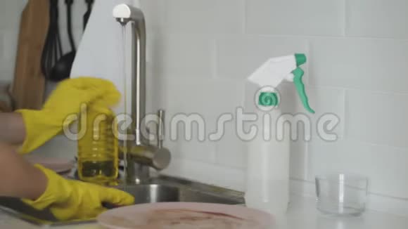 一个女人在厨房的水槽里洗盘子视频的预览图