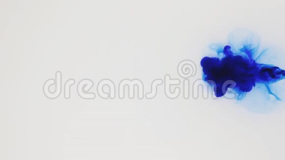 彩色颜料流在水中彩色墨云抽象的动作白色背景上的蓝色染料视频的预览图