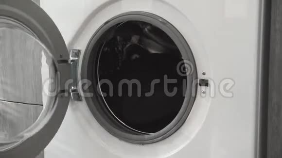 女性手从洗衣机里拿白色的衣服去装洗衣机把衣服装进洗衣机负荷视频的预览图