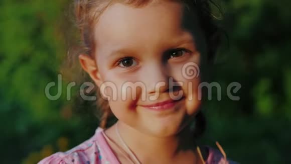 可爱的小女孩棕色的眼睛看着相机微笑着视频的预览图