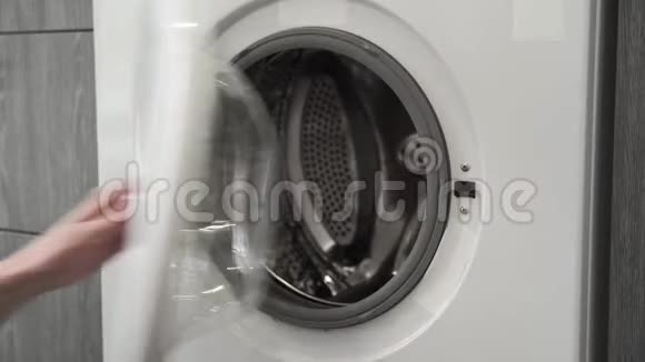 有结婚戒指的女性手把GRAY知道的帽子放在洗衣机里去装洗衣机把衣服装上洗衣机视频的预览图