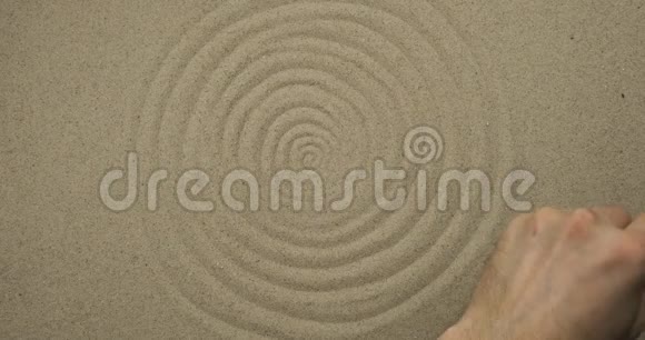 用棍子在沙子上画画抽象同心圆象征性的背景视频的预览图