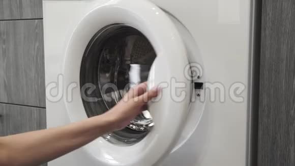 带结婚戒指的女性手把JEANS放进洗衣机里去装洗衣机把衣服装上洗衣机视频的预览图
