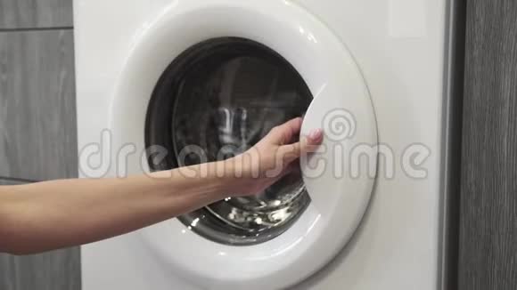 女性手把彩色的衣服放在洗衣机里去装洗衣机把衣服装进洗衣机负荷视频的预览图