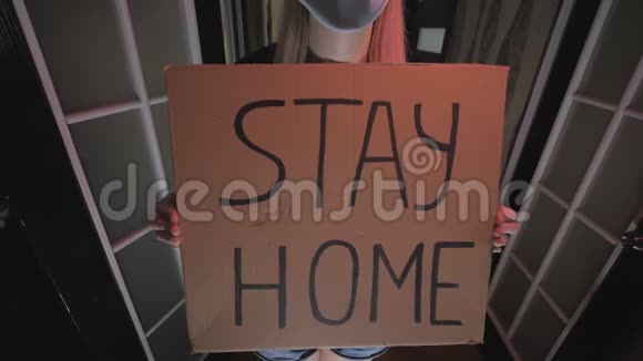 戴着面具的女人拿着一张有铭文的纸呆在家里检疫视频的预览图