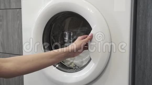 女性手从洗衣机里拿白色衣服去装洗衣机把衣服装进洗衣机负荷视频的预览图