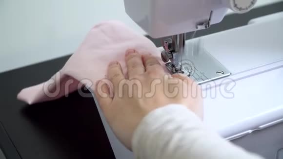 女人缝一个保护面具制作棉织物医用口罩保护病毒视频的预览图