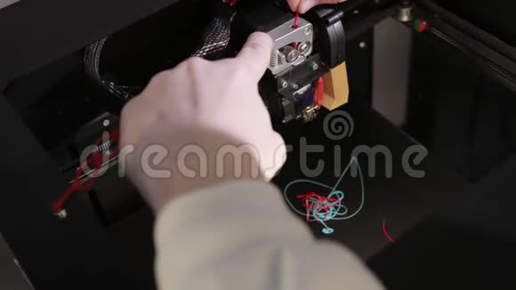3D技术两个人用手把塑料灰线插入打印机的尖头视频的预览图