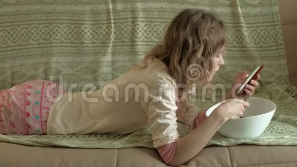 年轻的女人躺在沙发上做木耳沙拉视频的预览图