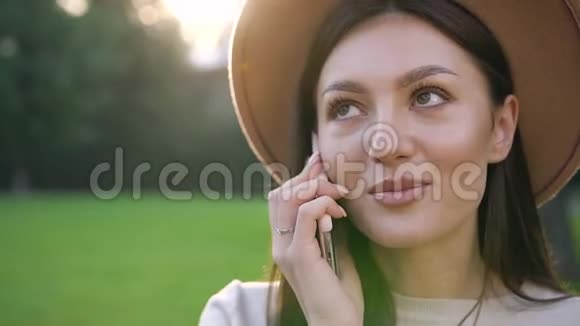 性格开朗可爱长得好看的女士戴着时髦的帽子在户外智能手机上聊天视频的预览图