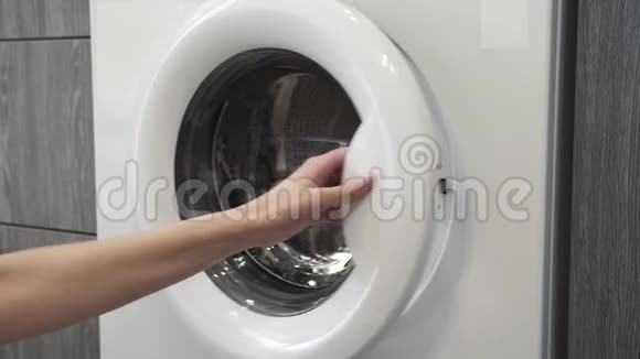 女性手带结婚戒指把白色的衣服放在洗衣机里去装洗衣机把衣服装上洗衣机视频的预览图