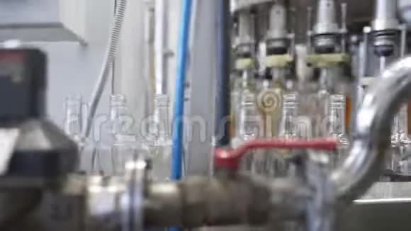 玻璃瓶沿输送线移动灌装机与控制面板在工厂装瓶酒精视频的预览图