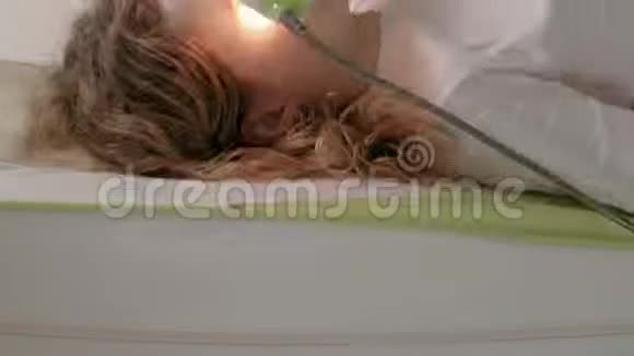一个女人躺在按摩床上用玉辊视频的预览图