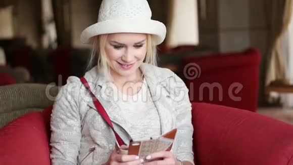 漂亮的金发商务女性使用智能手机视频的预览图