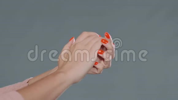 年轻女子用红色指甲擦手消毒视频的预览图