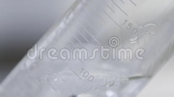 宏观透明液体填充容量实验室瓶女人拿酒精样本在酒厂化验视频的预览图