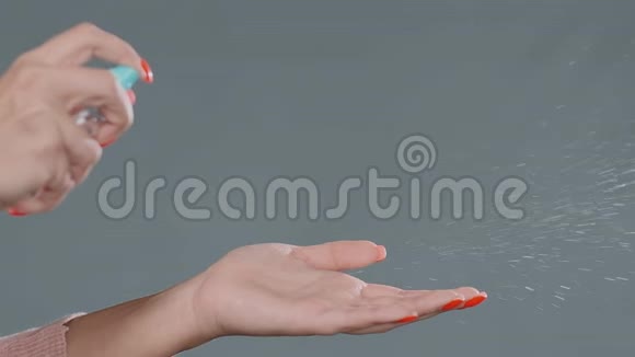 女人用红色指甲在手掌上喷洒防腐剂视频的预览图