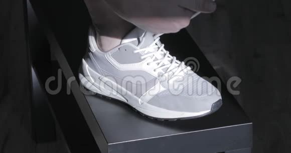人手系上灰色运动鞋视频的预览图
