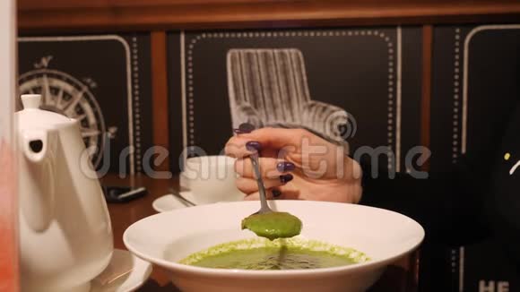 女人吃奶油汤的侧视视频的预览图