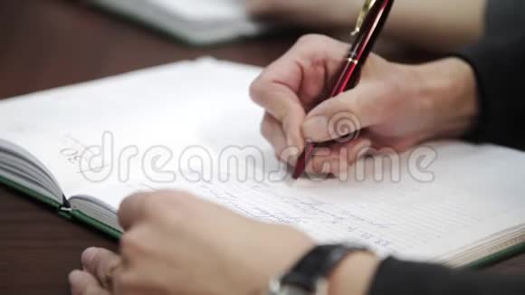 女性手拿笔用笔在笔记本乳品店做清单或业务数据手写商业报告视频的预览图