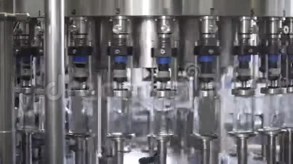 在工厂的玻璃瓶里溢出伏特加带玻璃瓶的传送带酒精饮料溢漏视频的预览图
