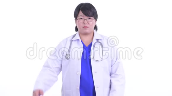困惑的超重亚洲女医生在拇指向上和拇指向下之间做出选择视频的预览图