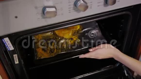 用烤炉里烤的腌料煮整条烤鱼女厨师把烤盘和生鱼放进热锅里视频的预览图