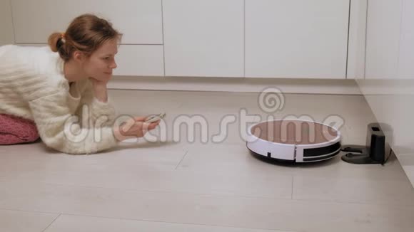 一个年轻的女人用吸尘器控制机器人视频的预览图