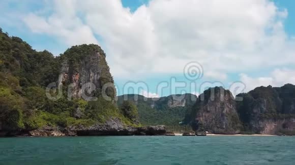 从位于克拉比的海上海岸和热带绿色植物覆盖的悬崖上的移动船上观看视频的预览图