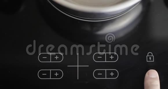 人按下电炉上的按钮男性手包括感应炉现代技术电动触摸屏视频的预览图