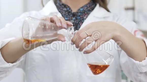 女科学家分析酒厂实验室研究员的液体化学物质与酒精混合的缓慢运动视频的预览图