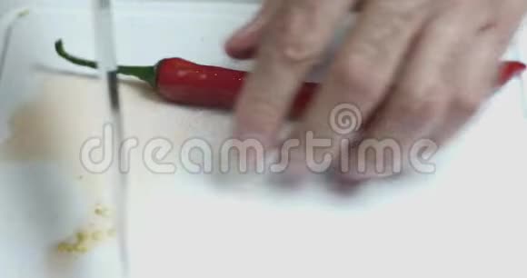 一个厨师的特写手用一把刀在切割板上切割新鲜的红辣椒素食健康营养食品视频的预览图