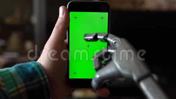 赛博格用电话一只灰色的机械手正在用绿色屏幕按压智能手机铬钥匙视频的预览图