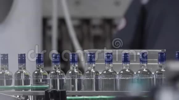 伏特加瓶装厂生产酒精饮料用输送机的工作机器玻璃瓶视频的预览图